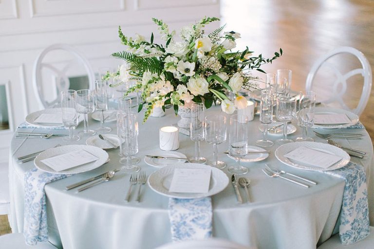 A side profile view of a low floral centerpiece featuring white wedding flowers on a white and light blue tablescape at Company 251. Photo by Tim Tab Studios.